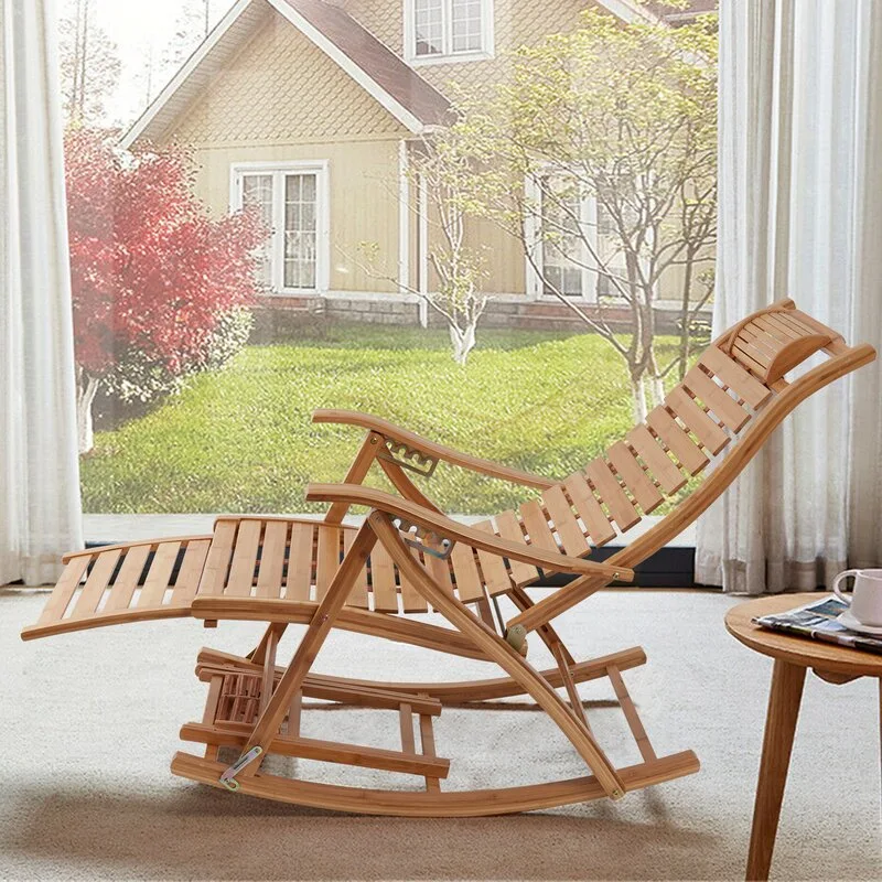 A slatted bamboo rocking lounge chair with an adjustable footrest sits on a light rug next to a small wooden side table.
