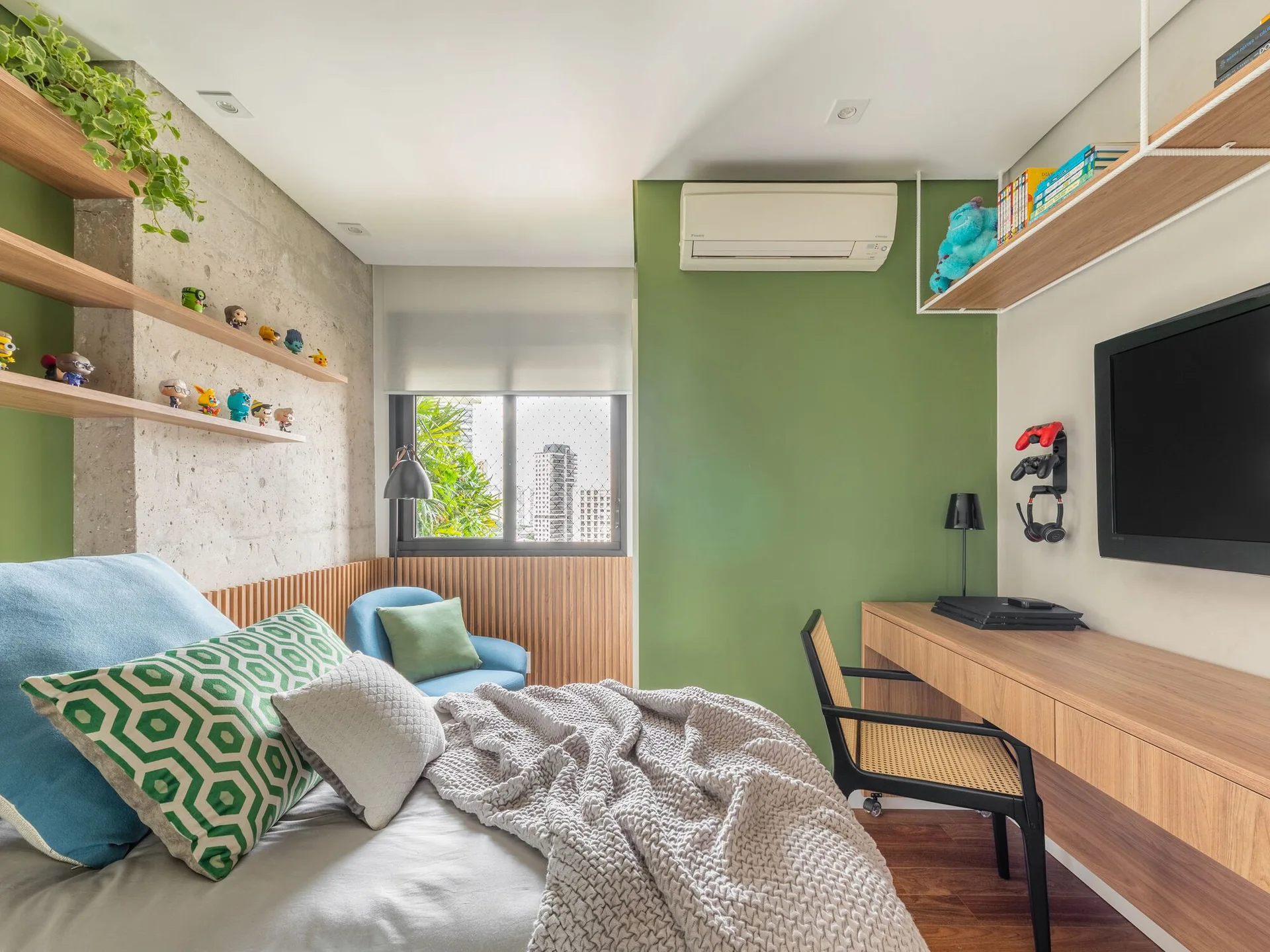 A modern bedroom with a bed, concrete feature wall, floating shelves, and an integrated wooden desk against a green accent wall.