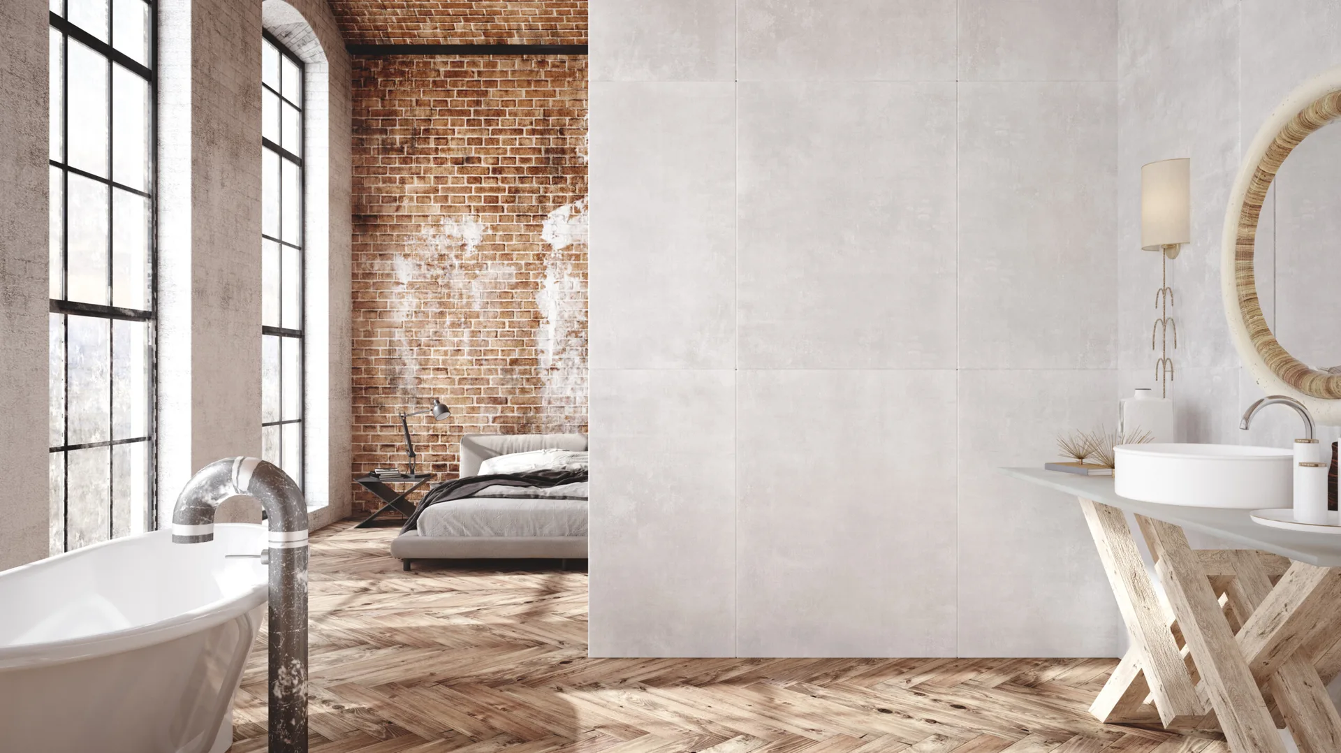 A modern loft bathroom and bedroom divided by a grey concrete partition wall, featuring herringbone wood floors and arched windows.