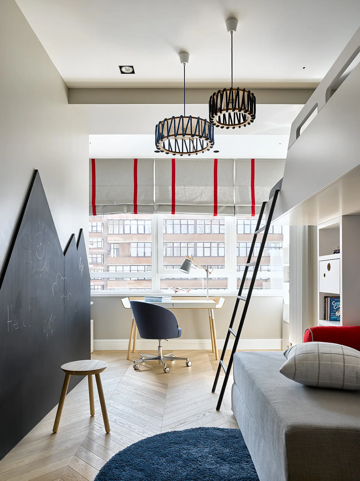 A kids' bedroom features a mountain-shaped chalkboard wall, a built-in bunk bed, a writing desk by the window, and herringbone wood floors.
