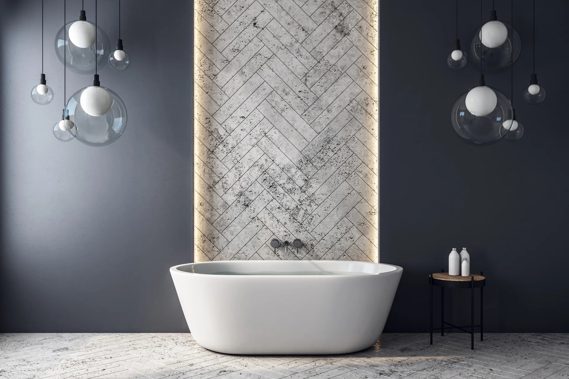 A minimalist bathroom featuring a white freestanding bathtub centered against a backlit herringbone stone feature wall flanked by dark charcoal walls.