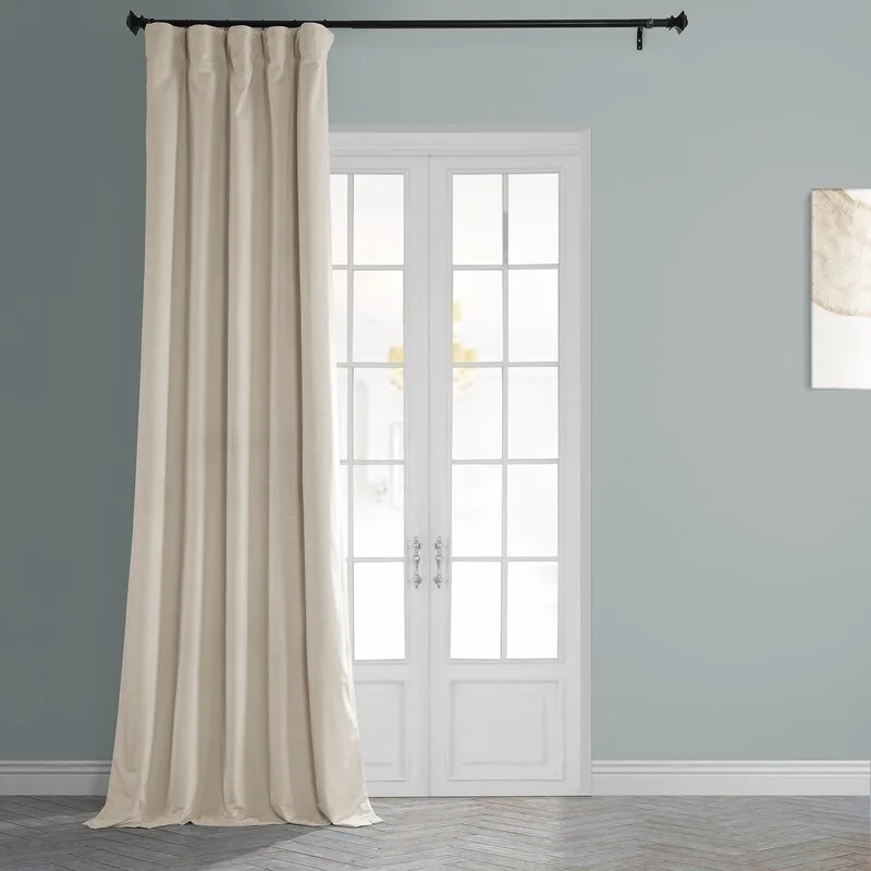 A floor-length beige curtain hangs from a black metal rod next to a white paned french door on a grey wall.