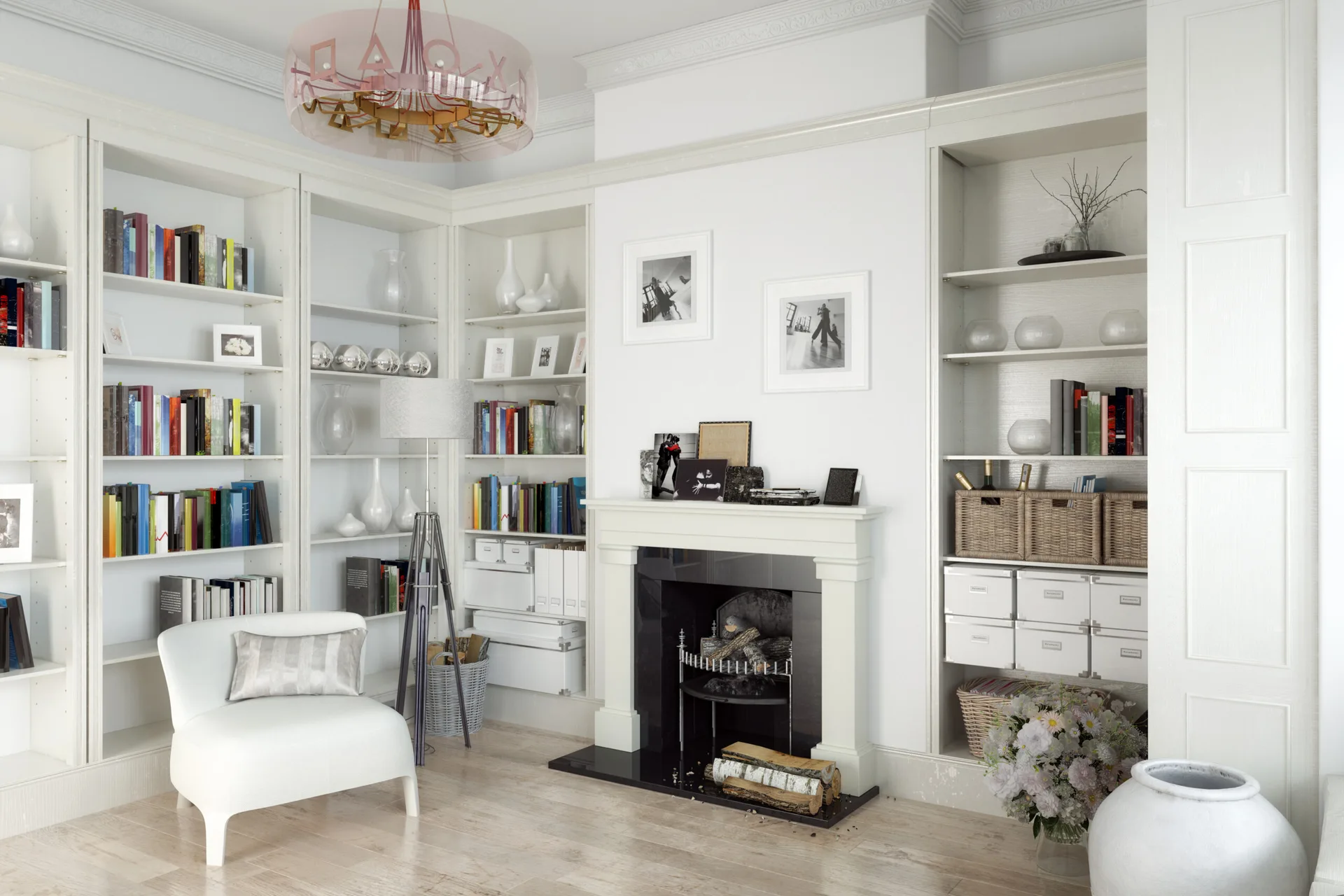 A white home library features built-in bookcases surrounding a black marble fireplace mantel, next to a white armchair and tripod floor lamp.