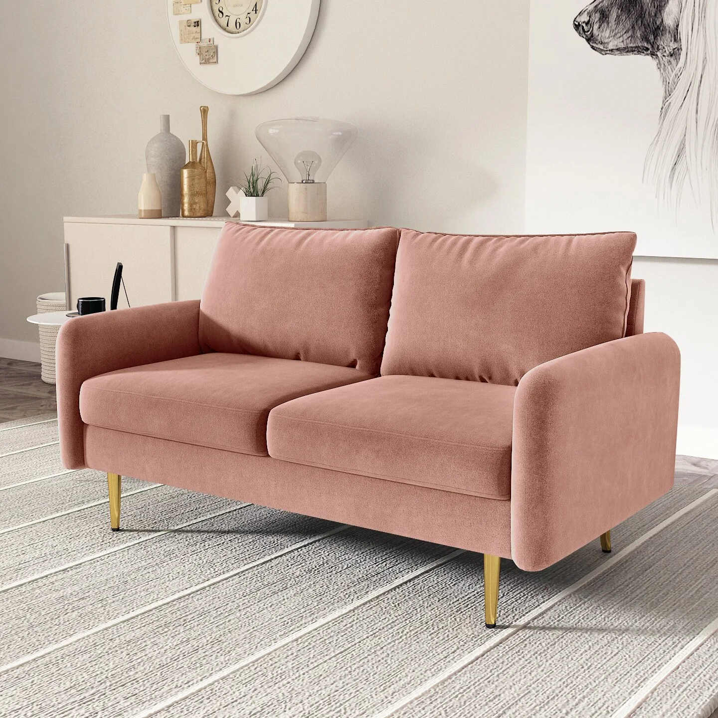 A dusty pink velvet sofa with brass legs is positioned on a striped grey rug in front of a light sideboard and neutral wall.