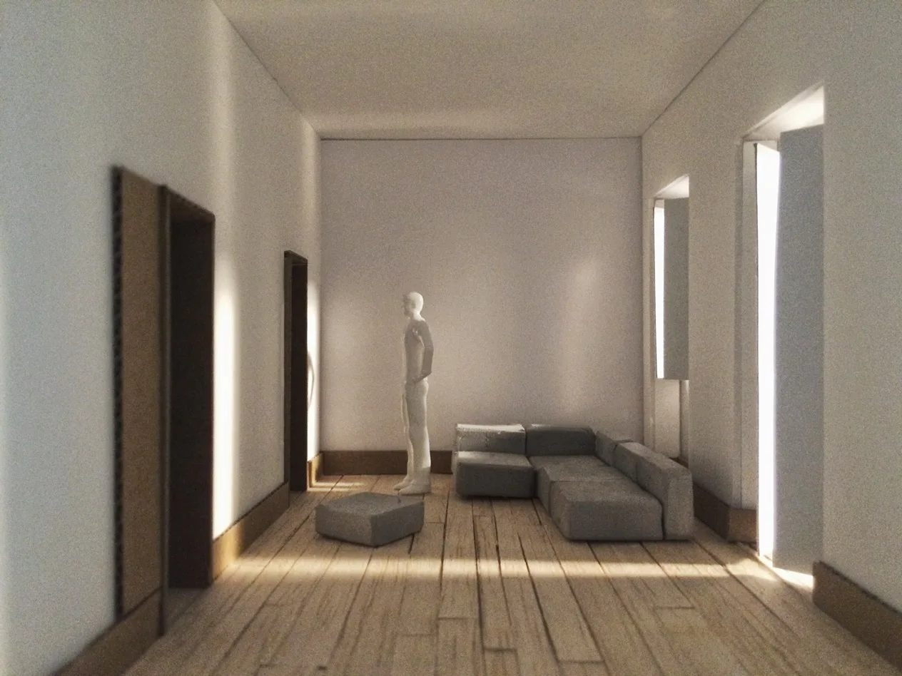 An architectural scale model of a minimalist living room featuring a grey sectional sofa, wooden plank floors, and a standing figurine.