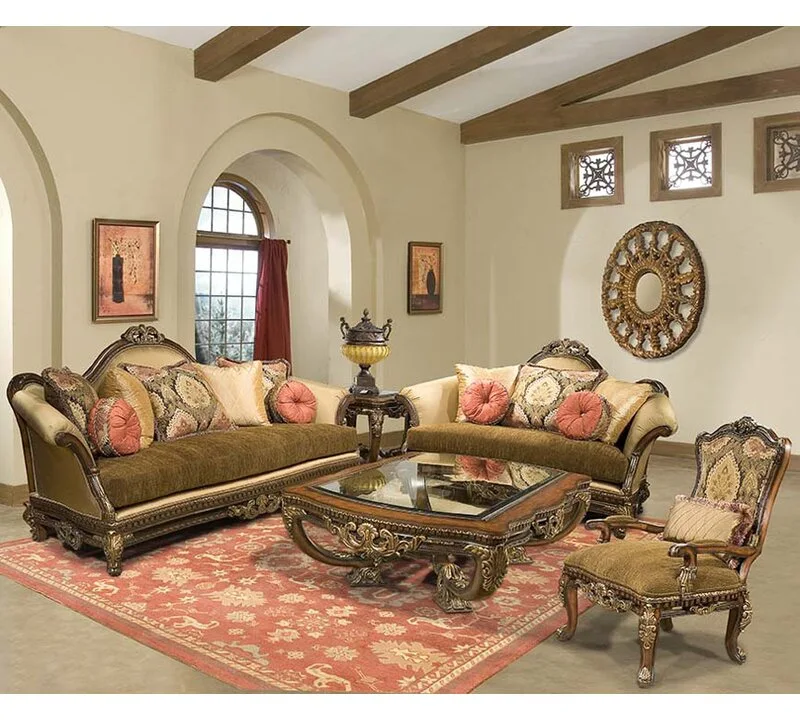 A formal living room features two traditional sofas with carved wood frames, a matching coffee table with a glass top, and a large patterned red rug.