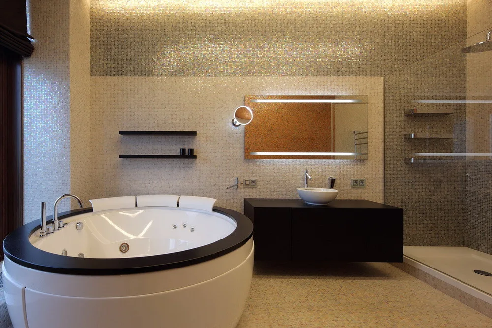 Modern bathroom featuring a circular jetted tub with a black rim, a floating vanity, and walls covered in iridescent mosaic tiles.