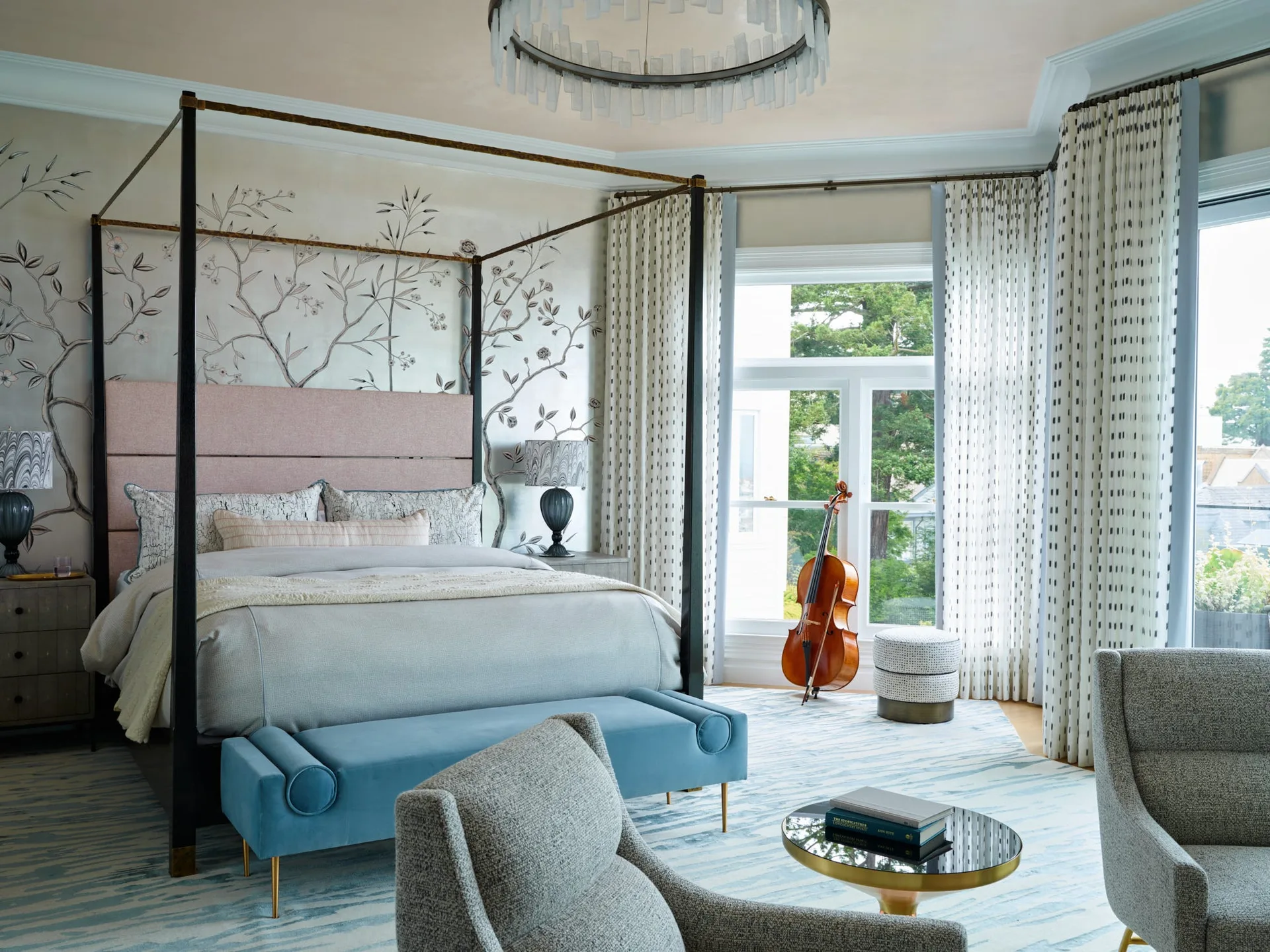 A bedroom features a black four-poster bed with a pink headboard, botanical line-art wallpaper, patterned curtains, and a blue bench on a blue-and-white rug.