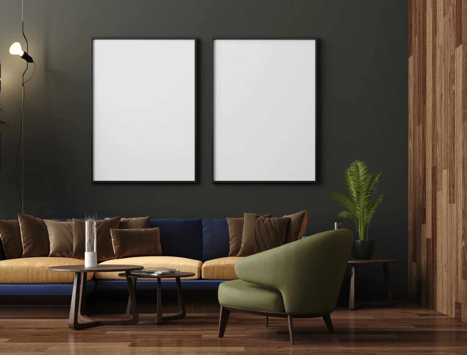 A modern living room features a blue and yellow sofa, a green armchair, and two large blank frames on a dark gray wall next to wood paneling.