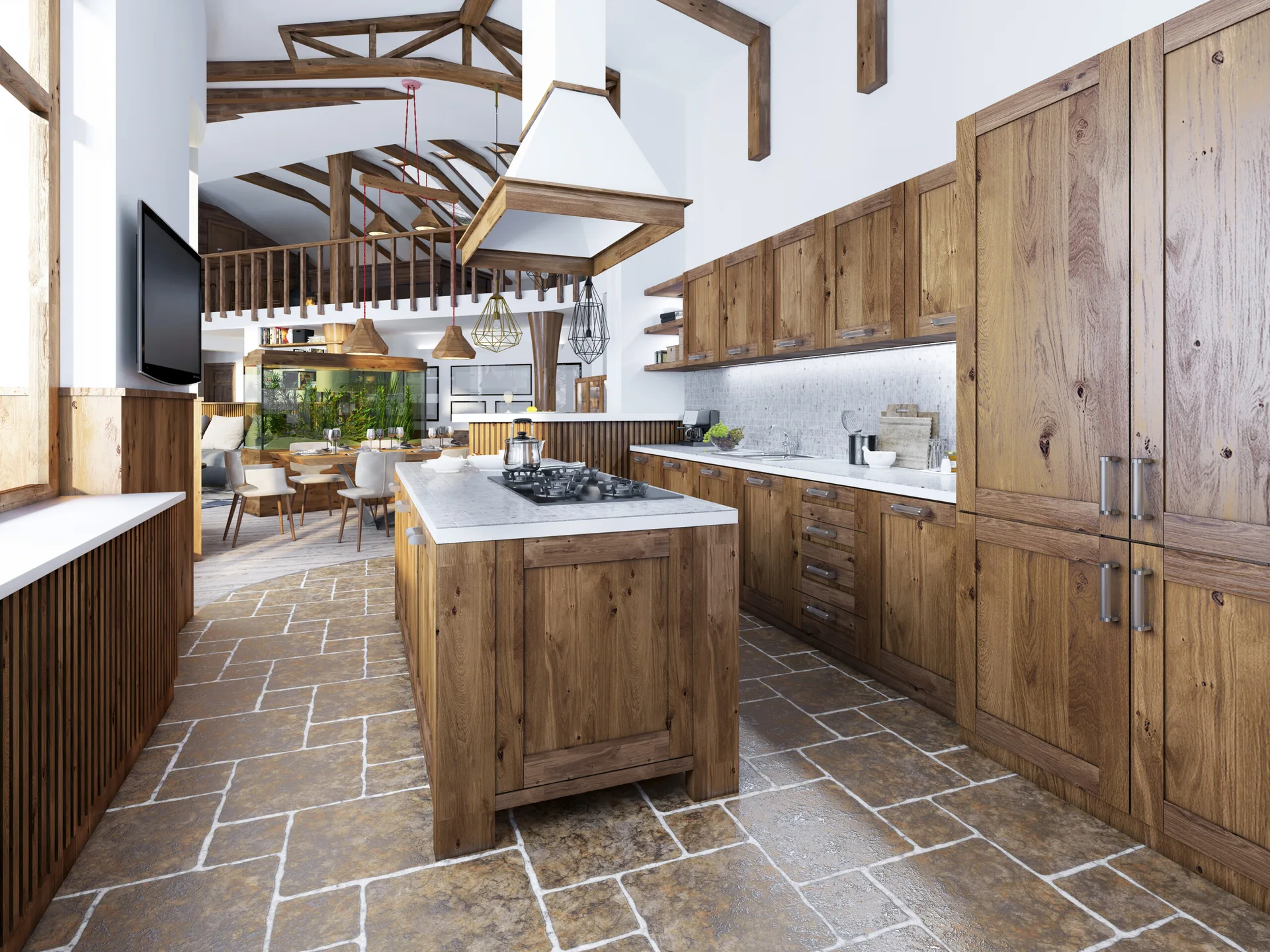 A spacious kitchen featuring natural wood cabinets, a central island with a cooktop, stone tile flooring, and vaulted ceilings with exposed timber beams.