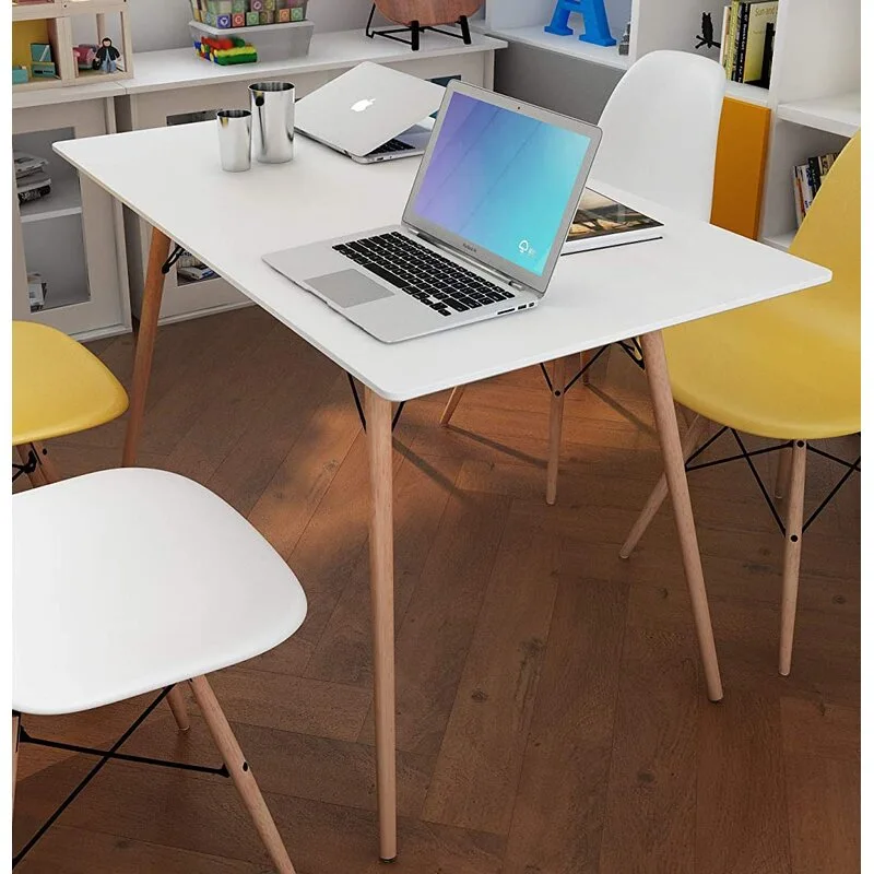 A white rectangular desk with tapered wooden legs is paired with molded plastic chairs in yellow and white on a herringbone wood floor.