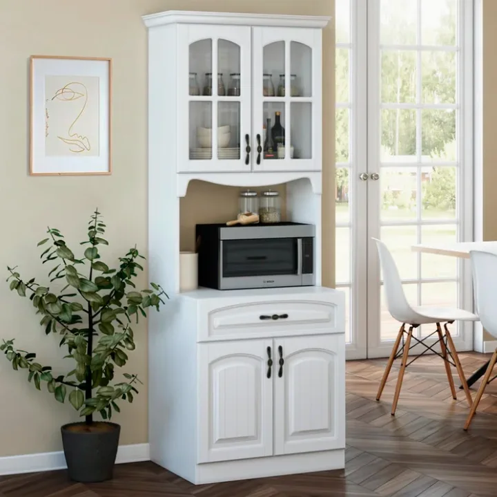 A white wooden kitchen storage hutch with glass doors and a microwave shelf sits on herringbone wood floors.