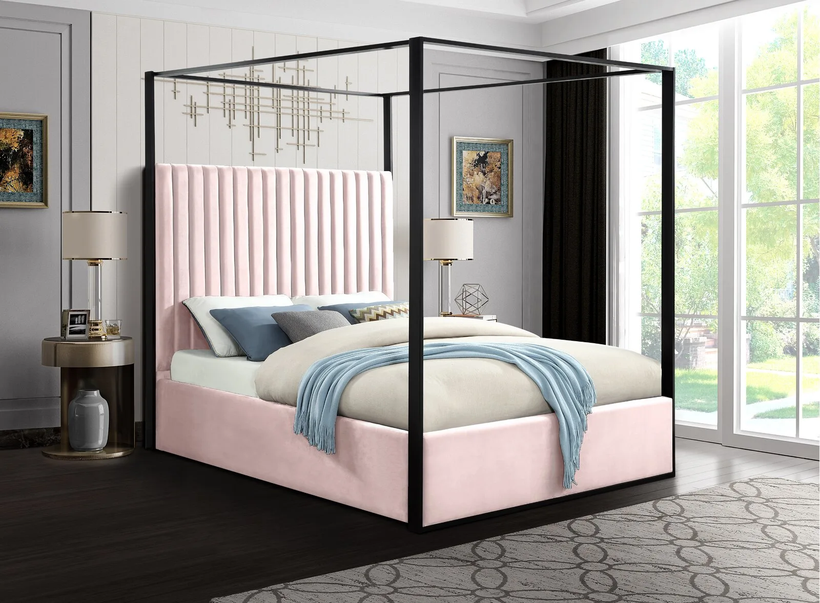 A contemporary bedroom features a pink tufted canopy bed with a black frame, situated next to round metallic nightstands on a patterned gray rug.