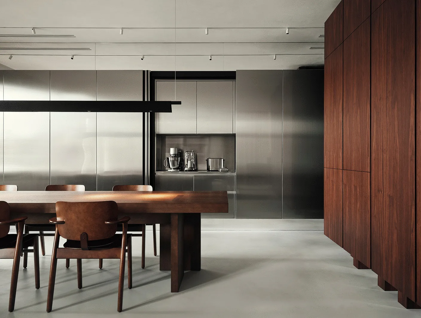 A minimalist dining kitchen features sleek stainless steel cabinetry, a dark wood dining table, and a matching wood pantry unit.