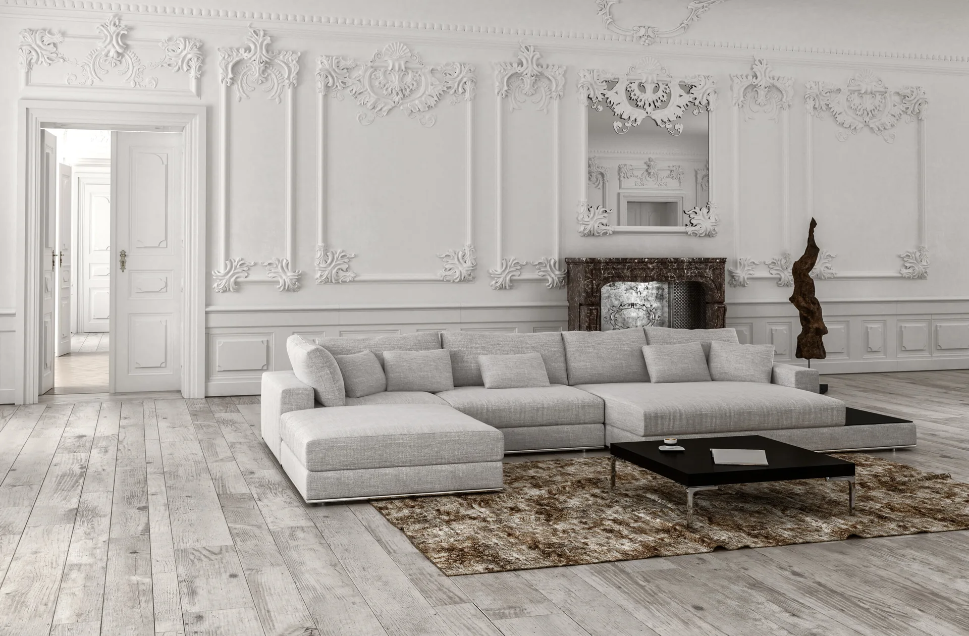 A modern grey sectional sofa sits on a brown textured rug in a room with ornate white wall moldings and a dark marble fireplace.