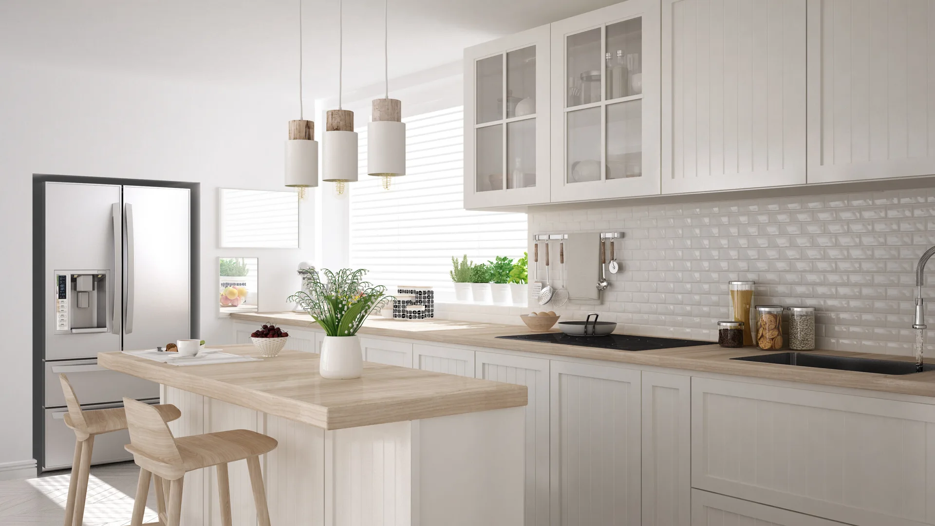 A bright white kitchen features shaker cabinets, a wooden-topped island with stools, a subway tile backsplash, and three hanging pendant lights.