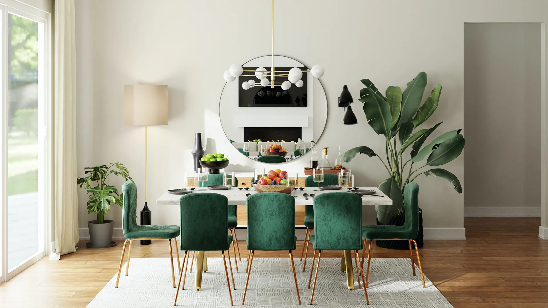 A modern dining room features a white table surrounded by emerald green velvet chairs beneath a large circular wall mirror and a globe chandelier.