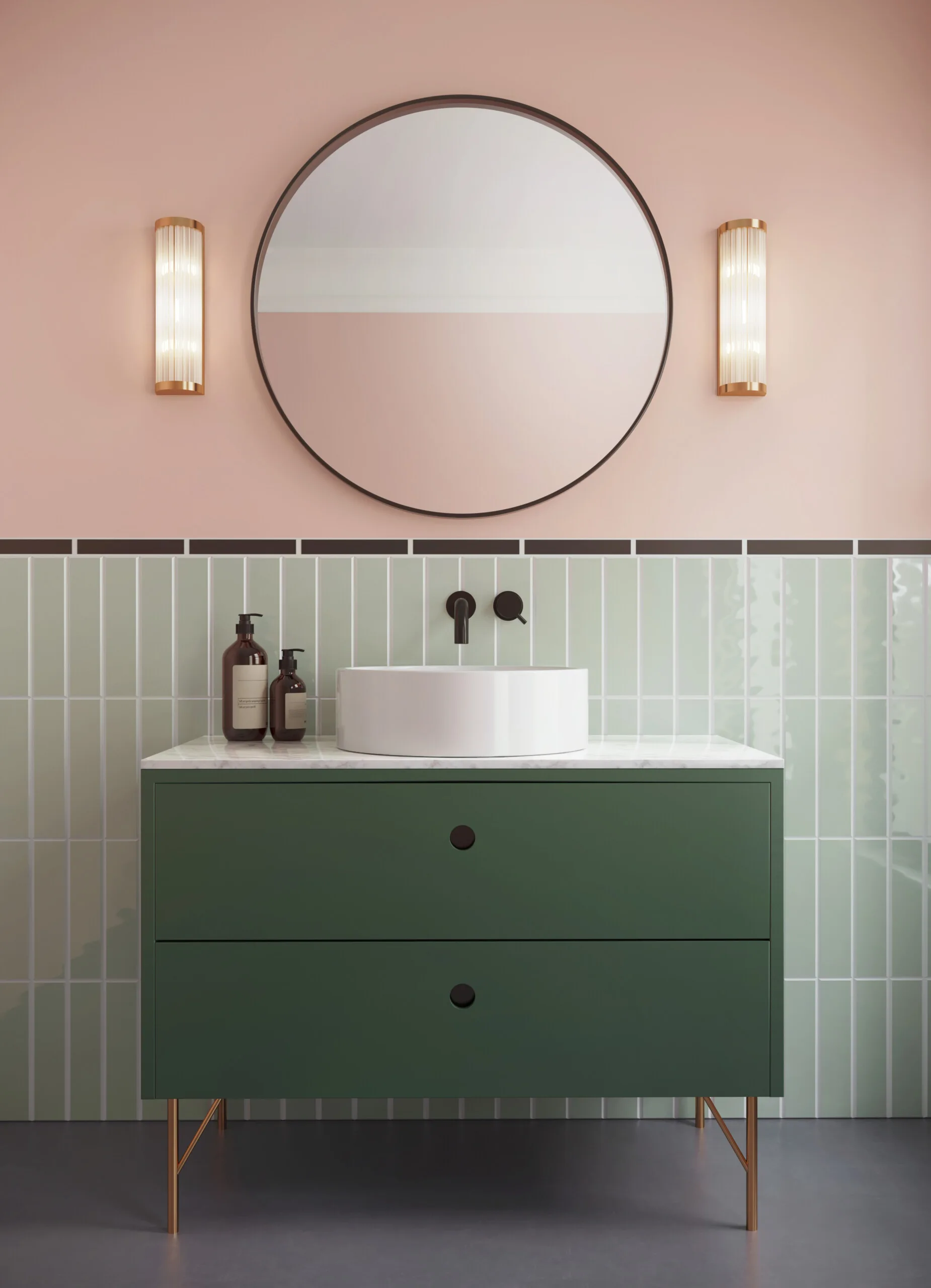 A modern green vanity with a white vessel sink stands against light green vertical subway tiles and a pale pink wall with a round mirror.