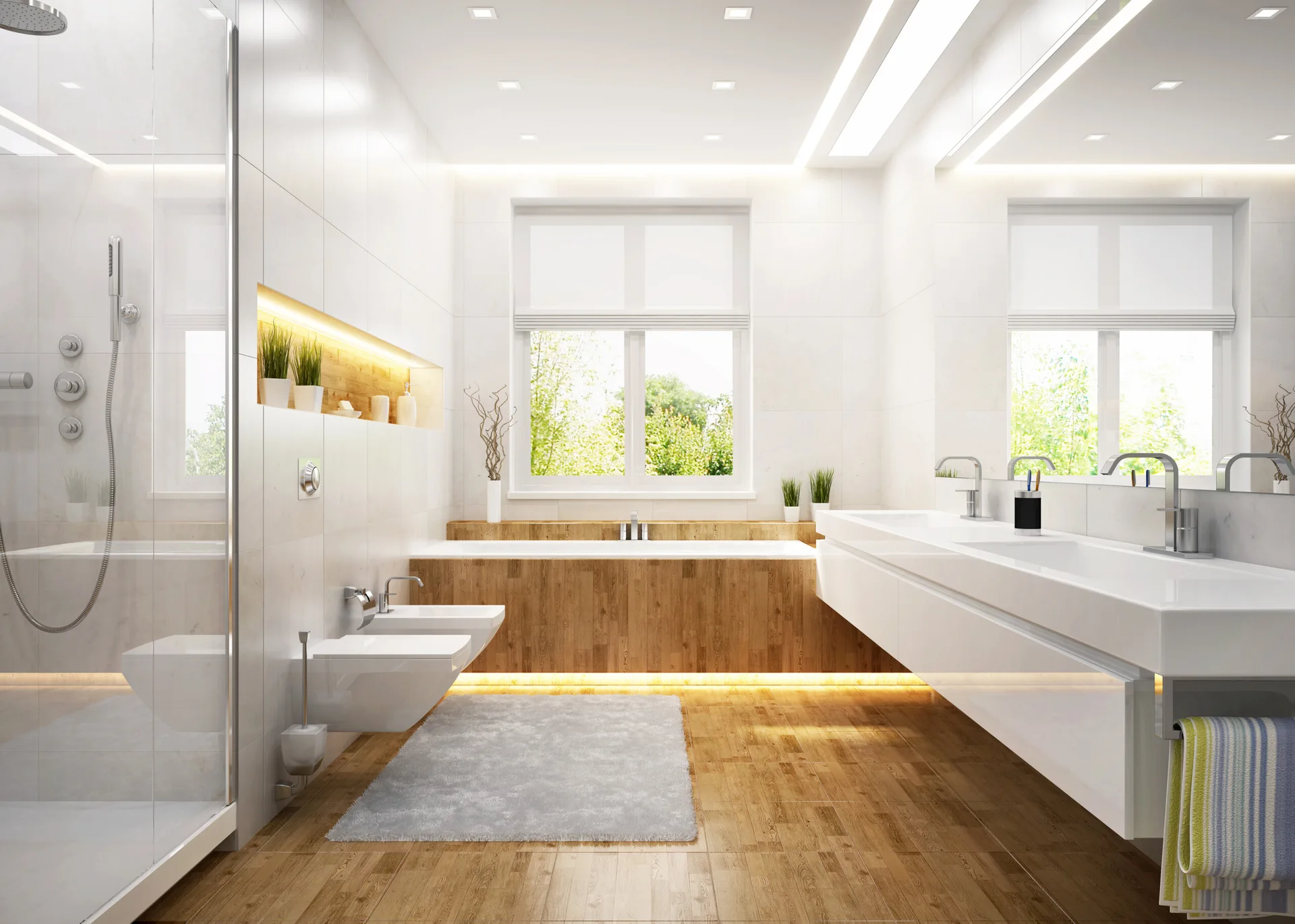 A modern white bathroom featuring a wood-surround bathtub under a window, a floating double vanity with under-cabinet lighting, and a glass shower.