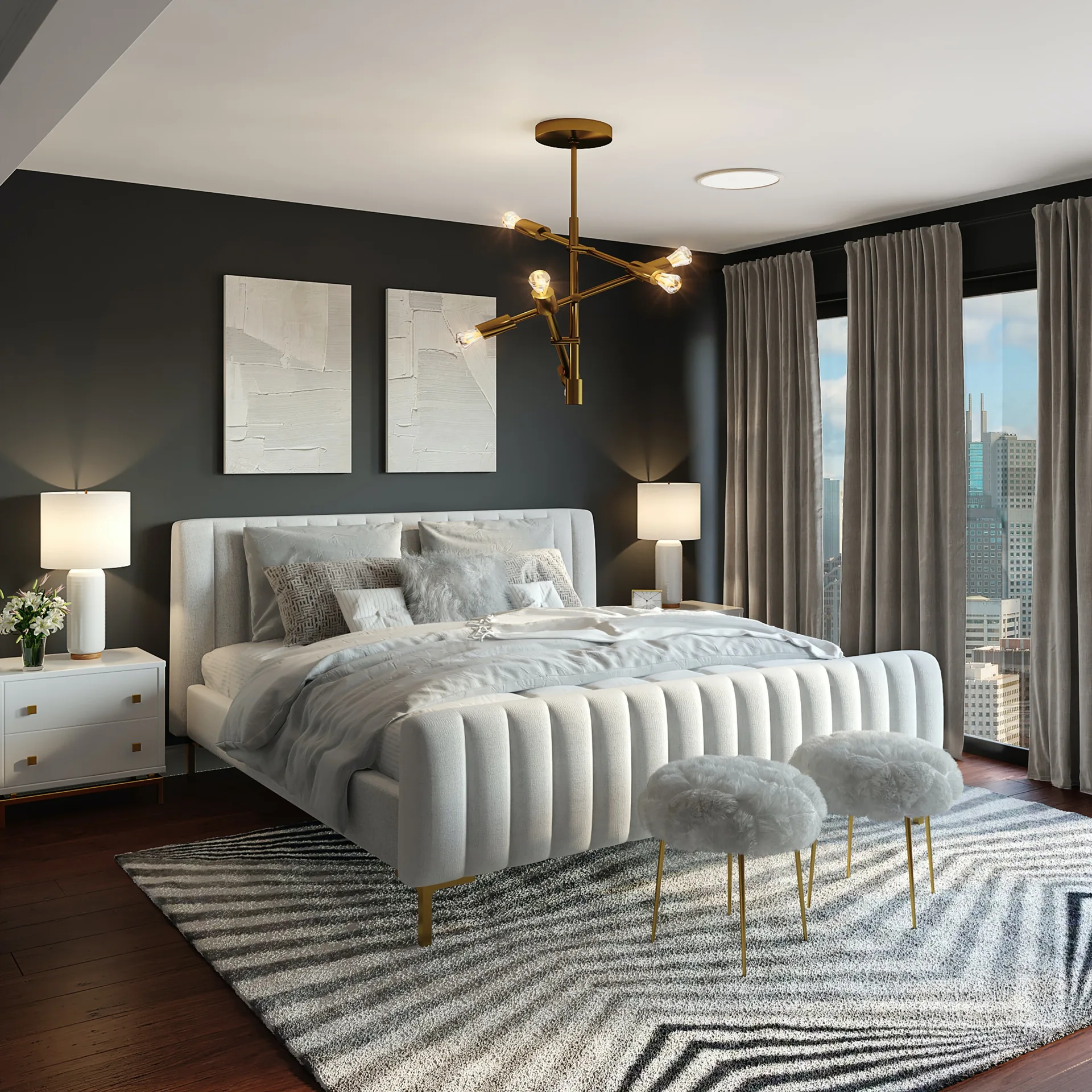 A modern bedroom features a cream channel-tufted bed against a charcoal accent wall, a gold branch chandelier, and a patterned grey area rug.