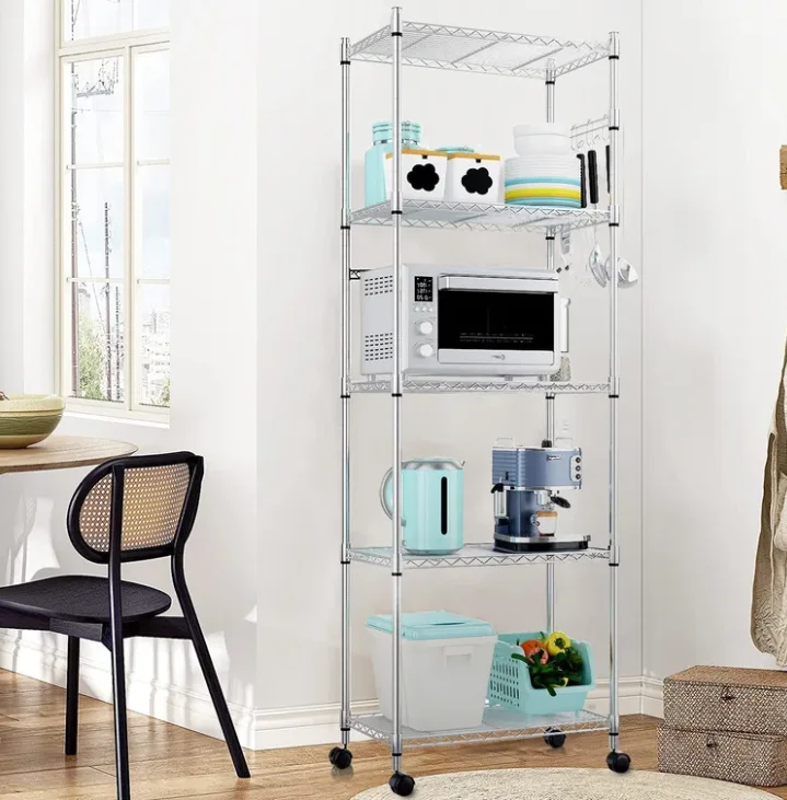 A five-tier chrome wire shelving unit holds a microwave, espresso machine, and blue containers in a bright dining area next to a cane-back chair.