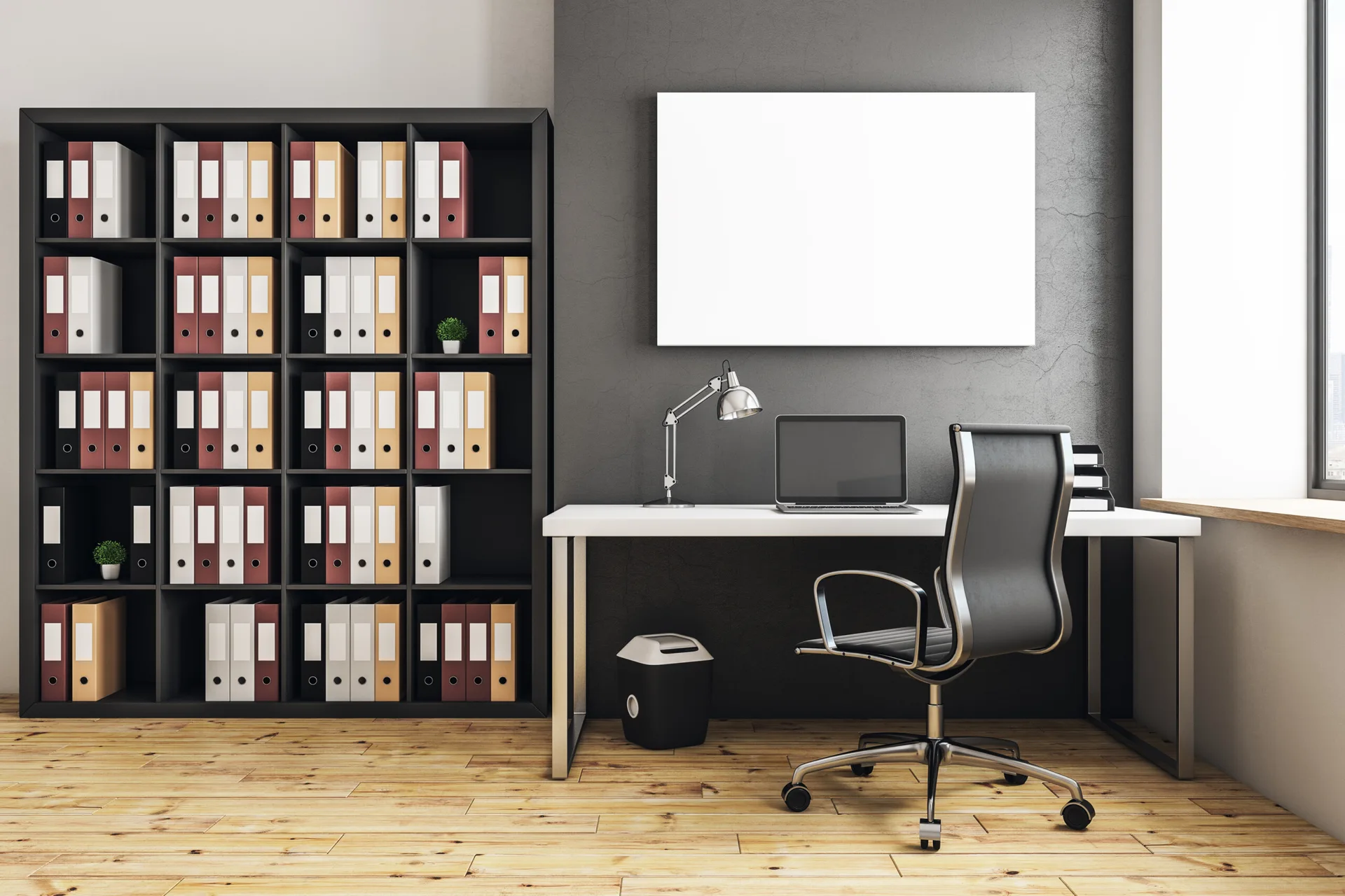 A modern home office features a white desk, a black office chair, and a large black bookcase filled with neat rows of binders.