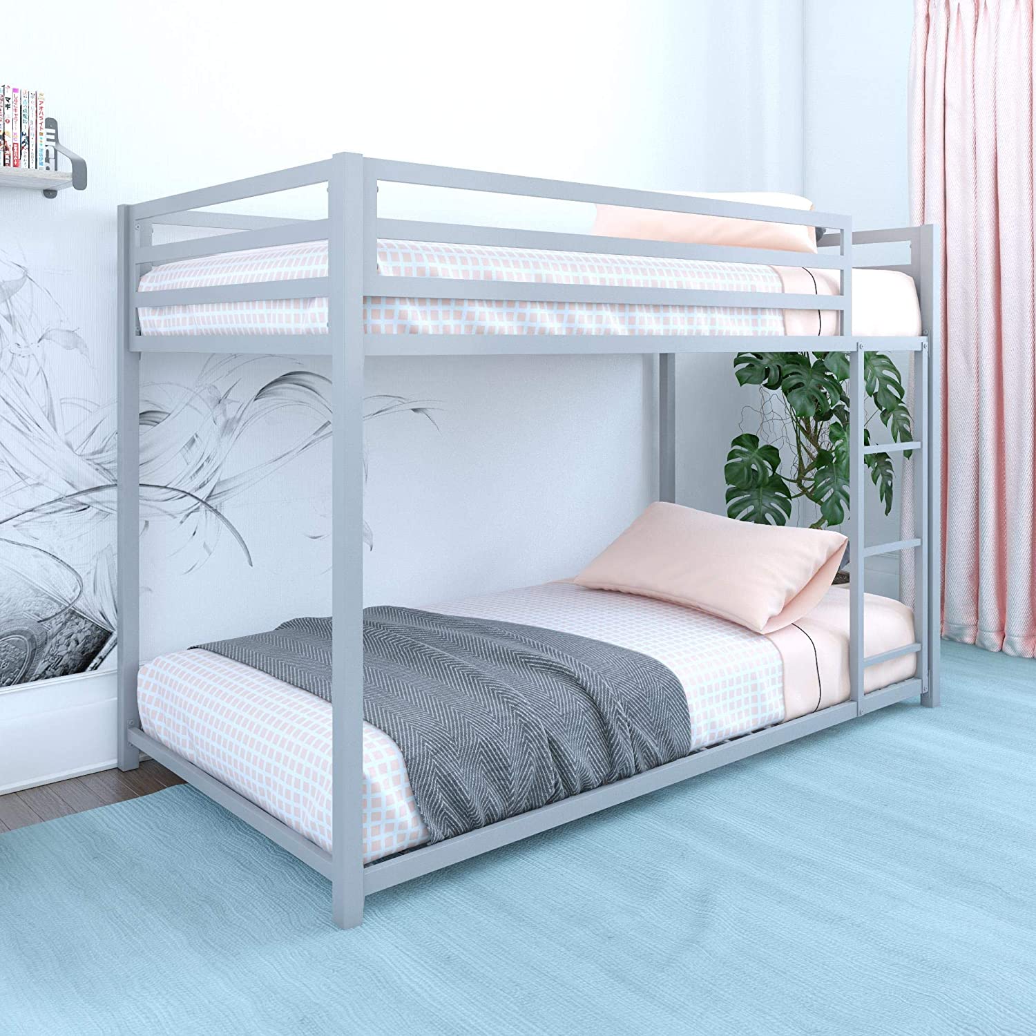 A grey metal bunk bed with pink and white checkered bedding stands on a blue wood-like floor next to pink curtains and a green houseplant.
