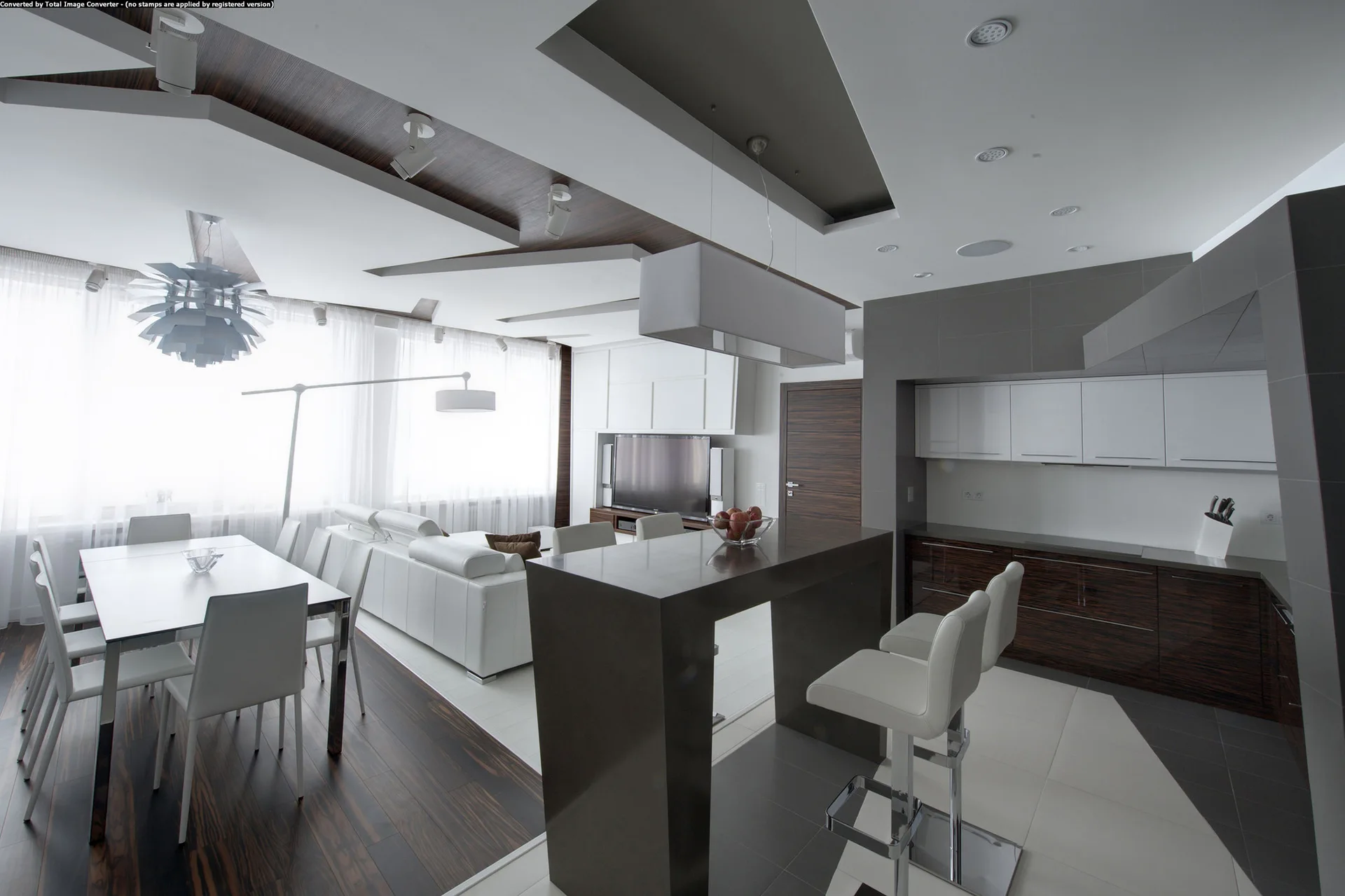A contemporary open-plan kitchen and dining area featuring a dark island, white leather bar stools, and a geometric dropped ceiling.
