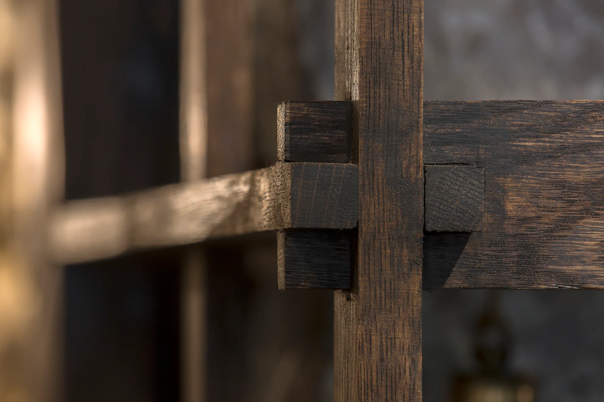 An extreme close-up of dark stained interlocking wooden joinery showing the natural grain and structural craftsmanship.