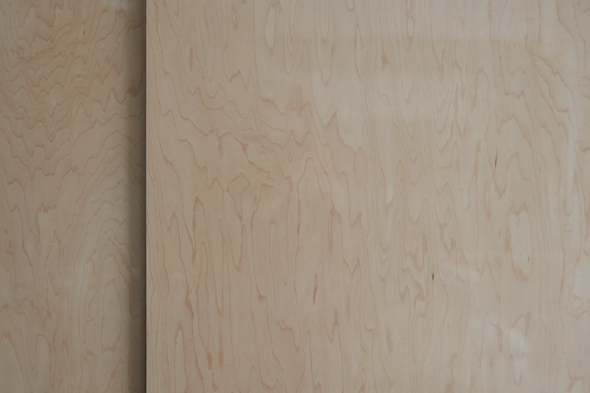 Two overlapping light beige wood veneer panels with a vertical seam showing a natural matte organic grain pattern.
