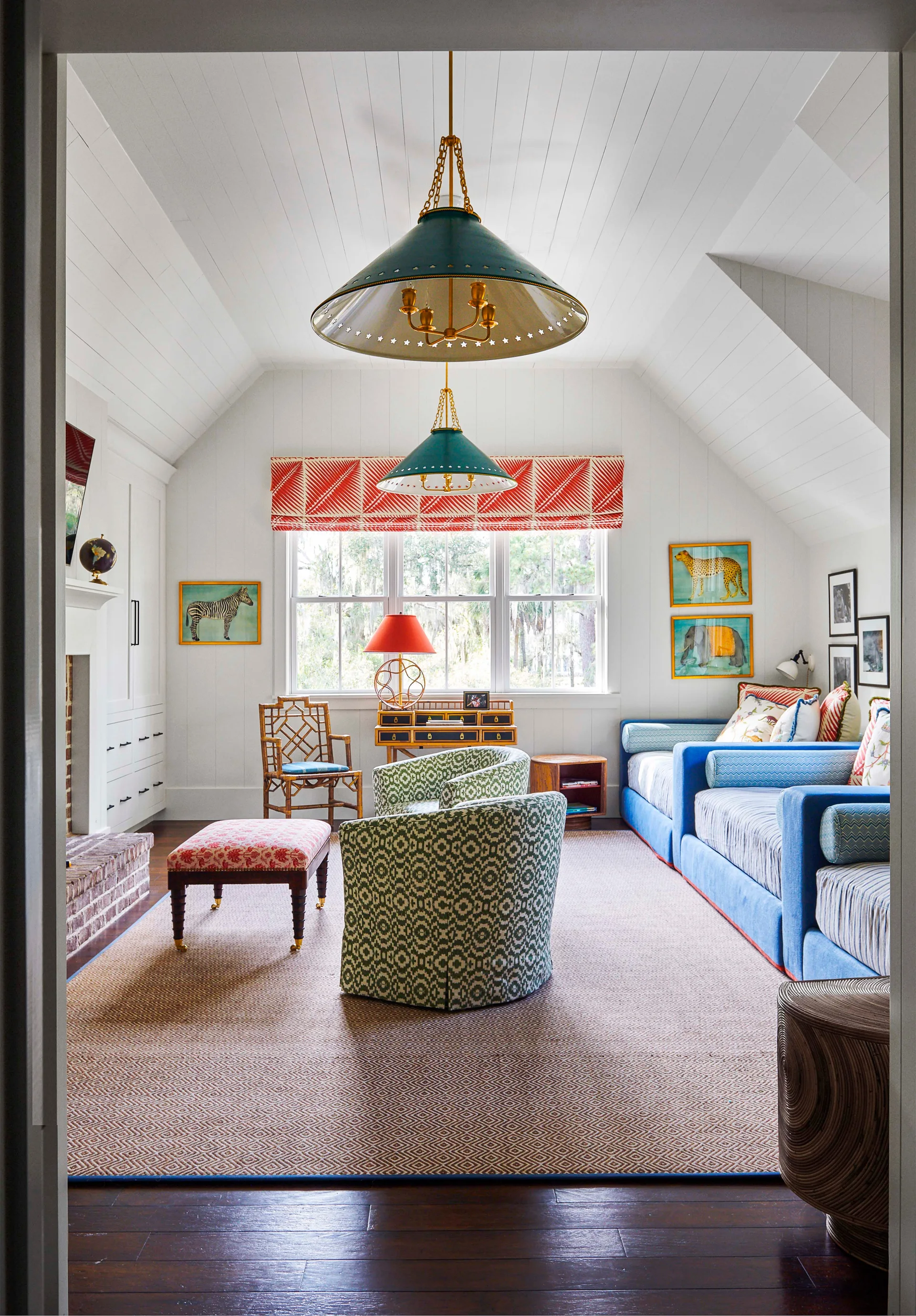 An eclectic attic family room with patterned green swivel chairs, a blue daybed, and green cone pendant lights under a vaulted plank ceiling.