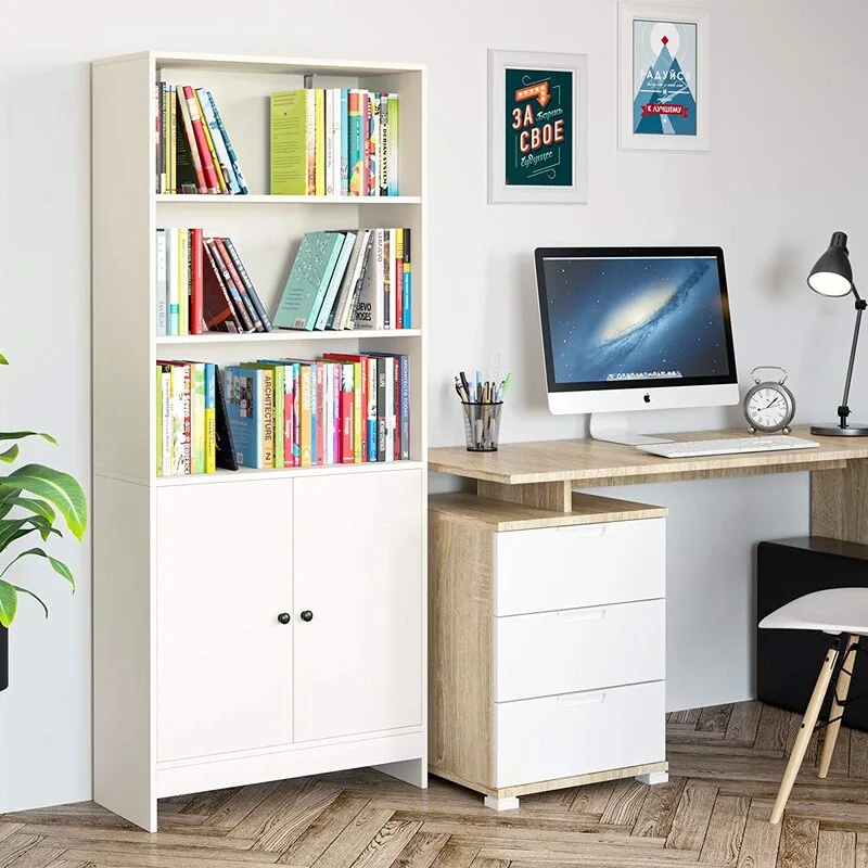 A light wood desk with white drawers stands next to a tall white bookshelf on a herringbone pattern wood floor.
