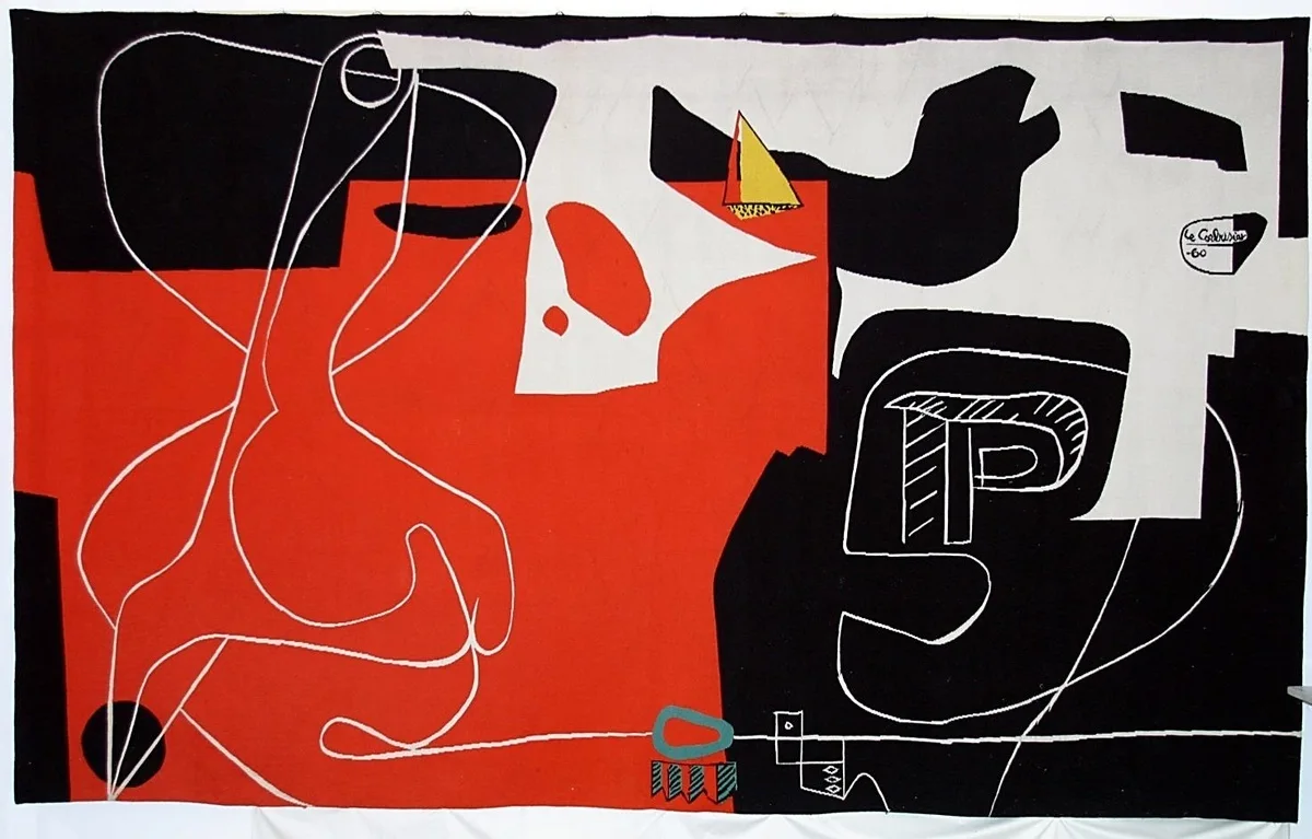 A large rectangular textile tapestry featuring abstract geometric shapes in bold black, red, and off-white with fine white outline details.