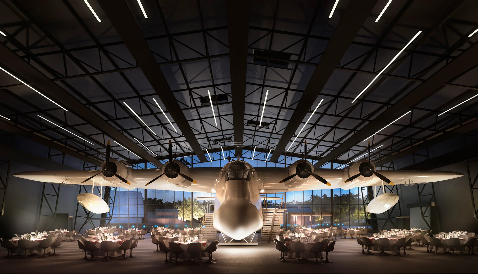 A spacious industrial hangar converted into a dining hall with a large vintage airplane parked in the center surrounded by round tables.