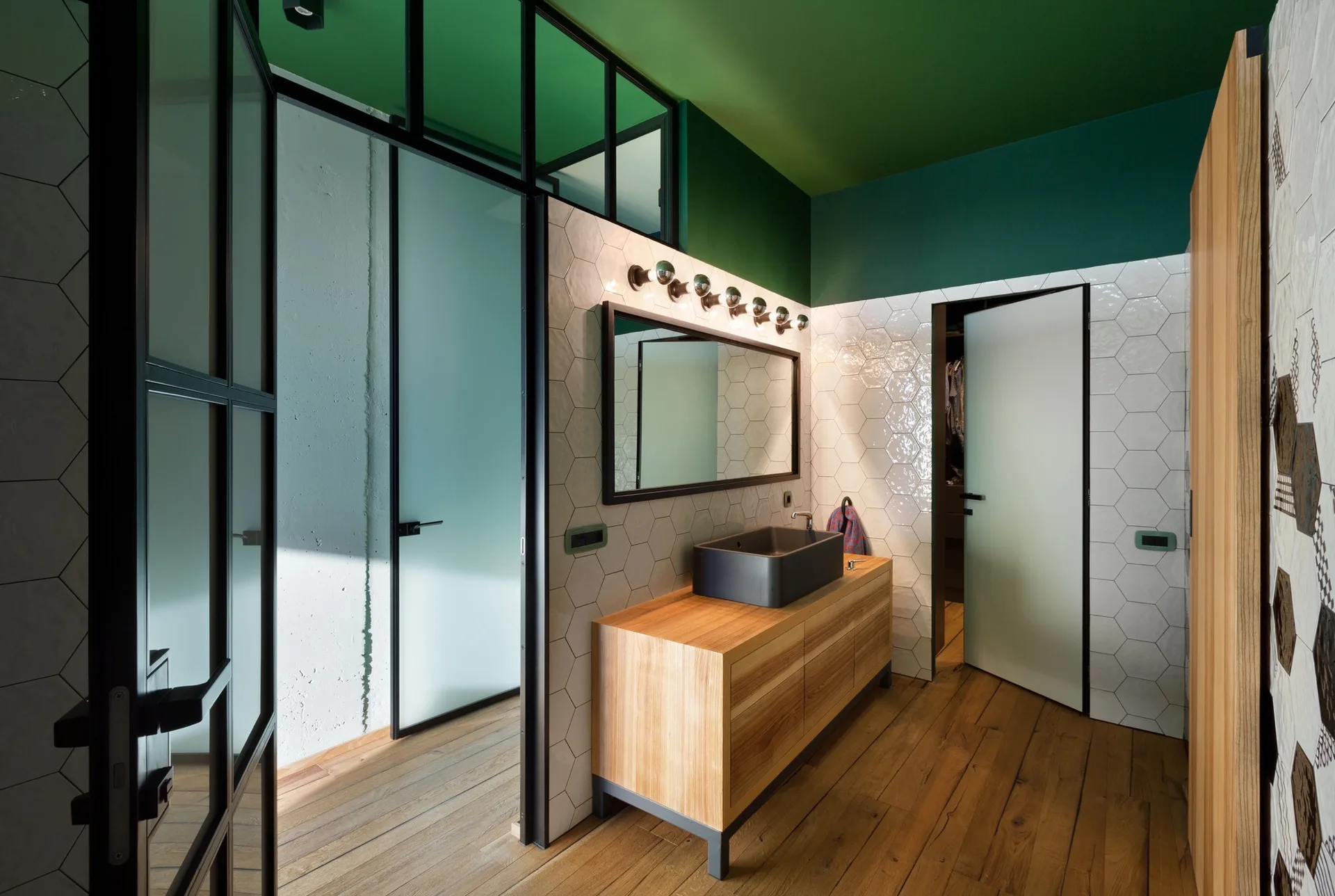 A bathroom featuring a wooden vanity cabinet with a black rectangular sink, white hexagonal wall tiles, and a bright green painted ceiling.