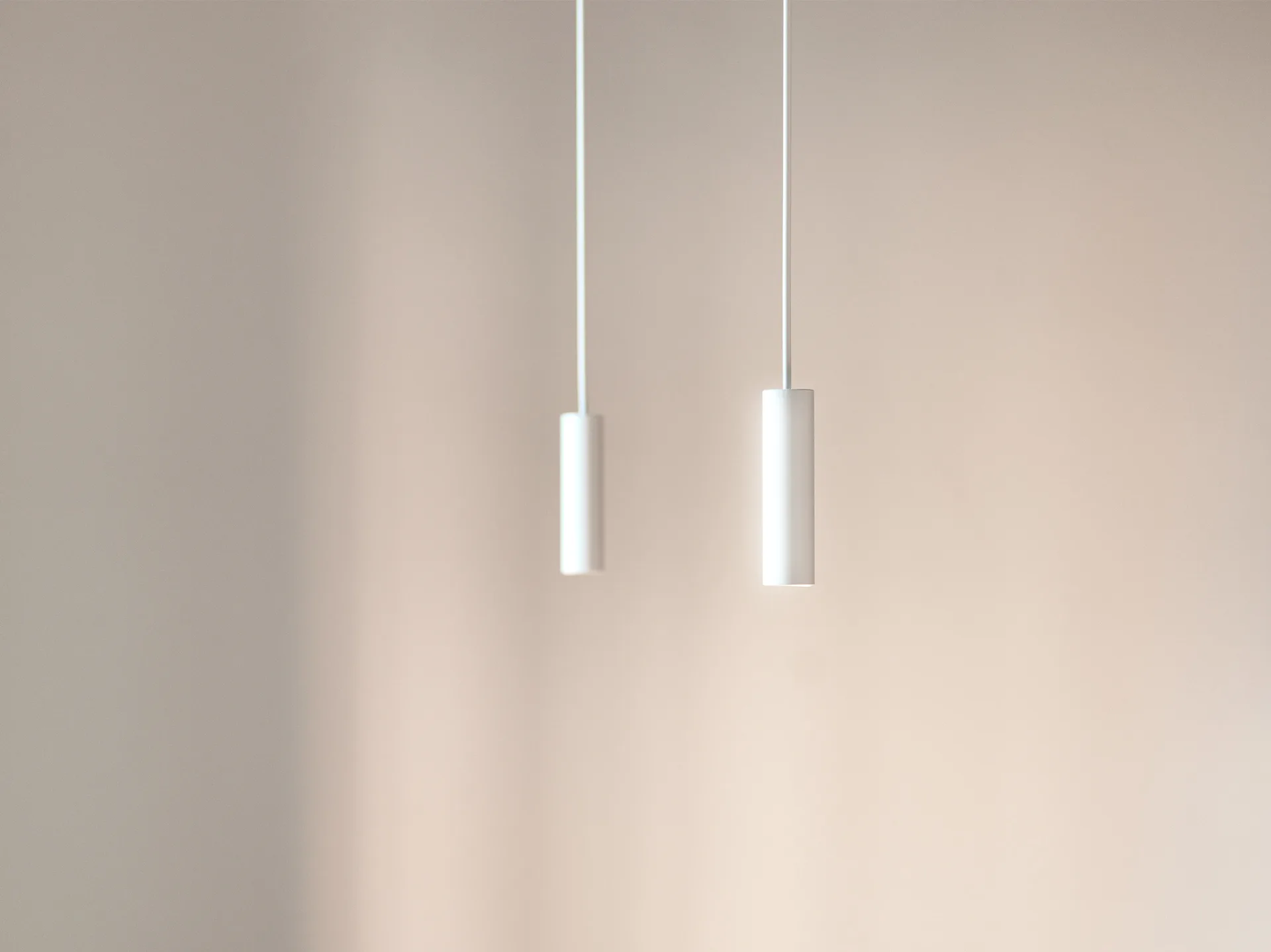 Two matte white cylindrical pendant lights hang from cords against a smooth, neutral beige wall.
