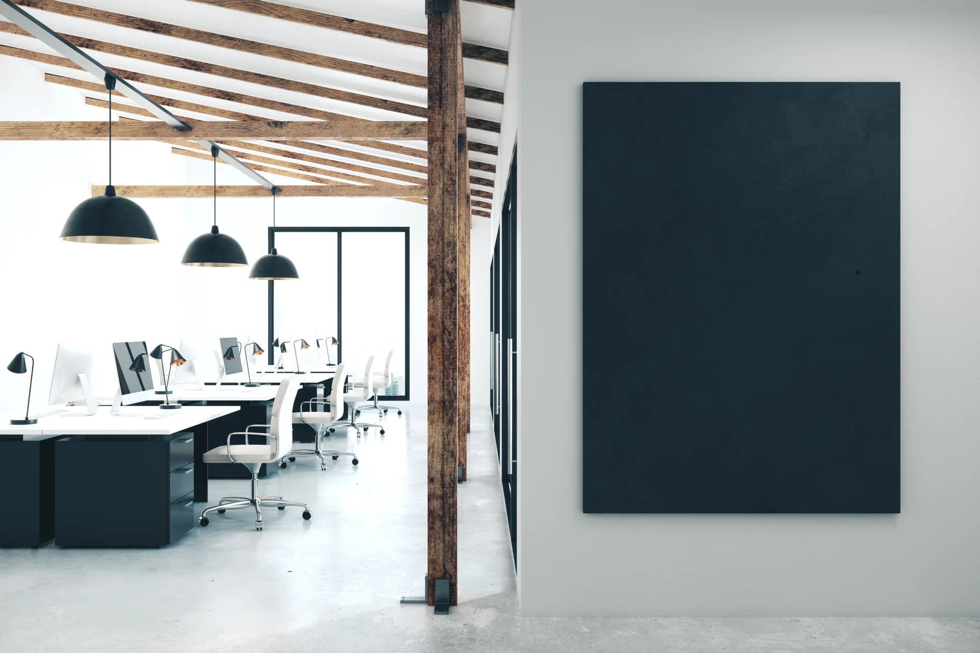 An open-plan office features white desks with black computers, black dome pendant lights, and exposed wooden ceiling beams.