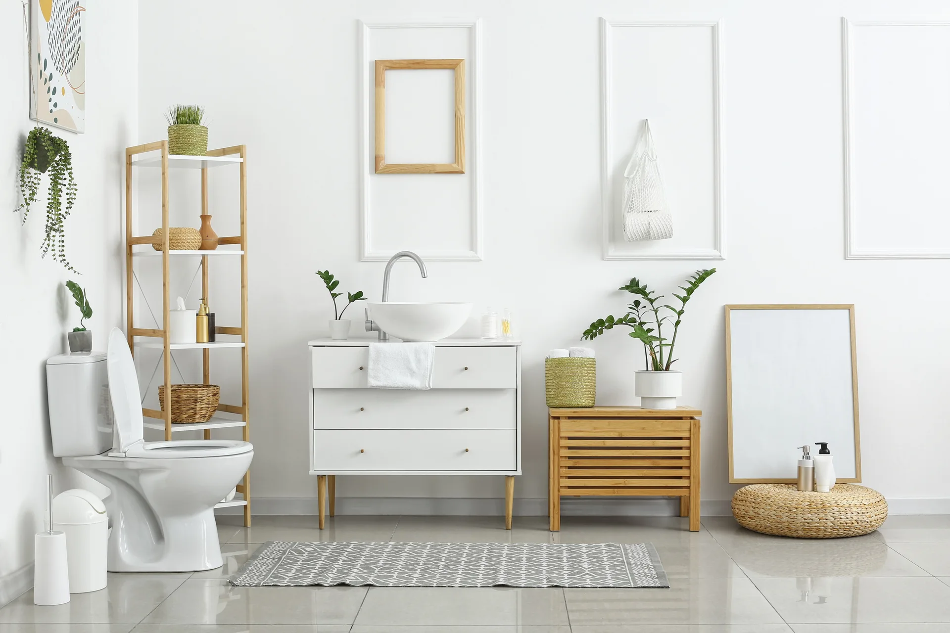 A minimalist white bathroom featuring a modern basin vanity, a tall wooden shelf, a slatted bench, and decorative rectangular wall molding.