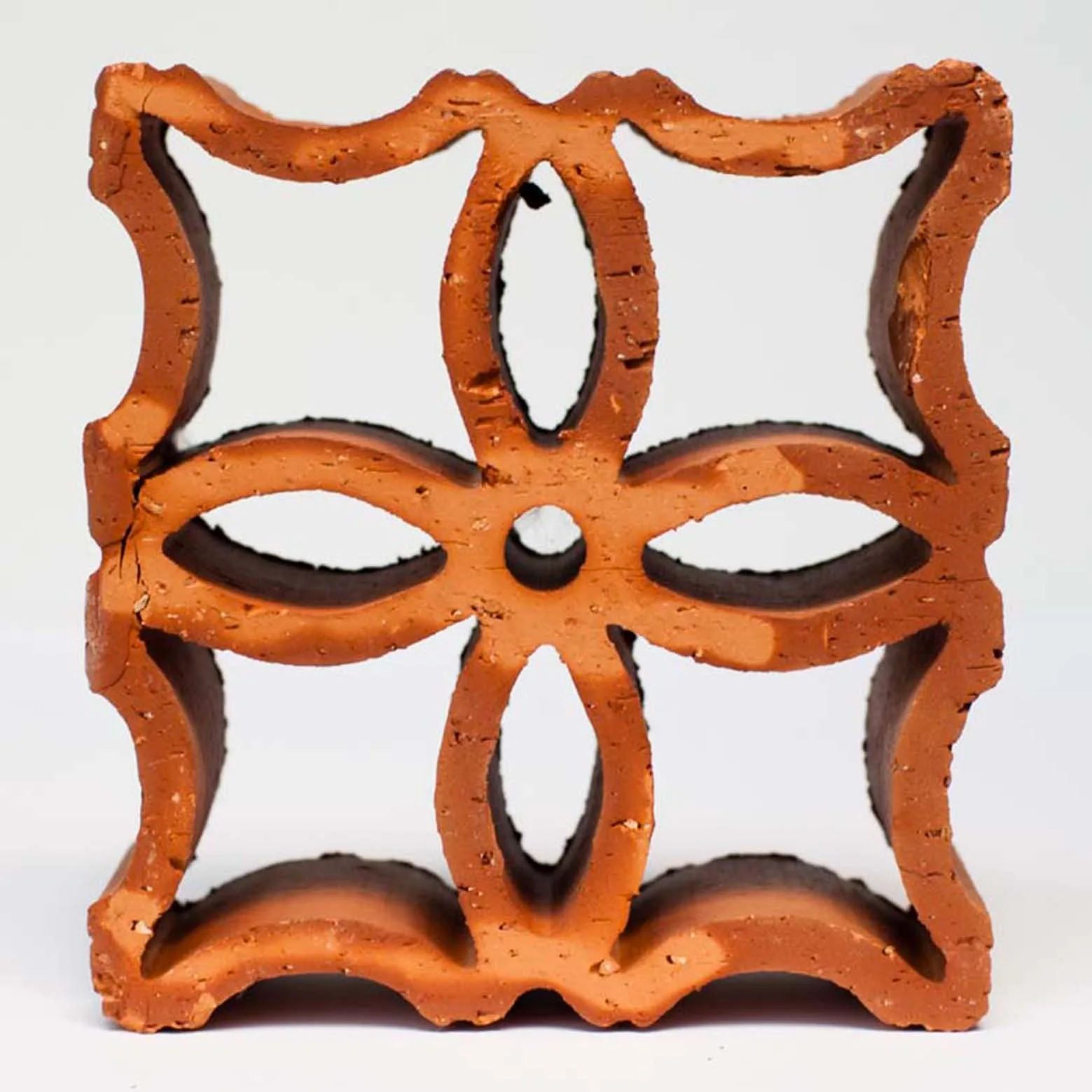 A square terracotta decorative screen block featuring an ornate, symmetrical floral cutout pattern, shown against a plain white background.