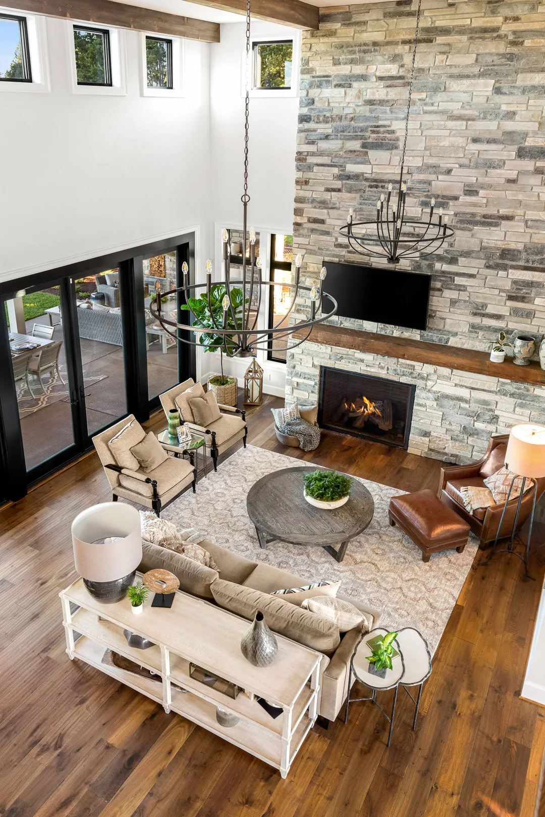 Modern living space with high ceilings and large stone fireplace&nbsp;