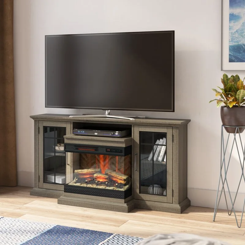 A grey wood television stand featuring an integrated electric fireplace in the center and glass cabinet doors on the sides.