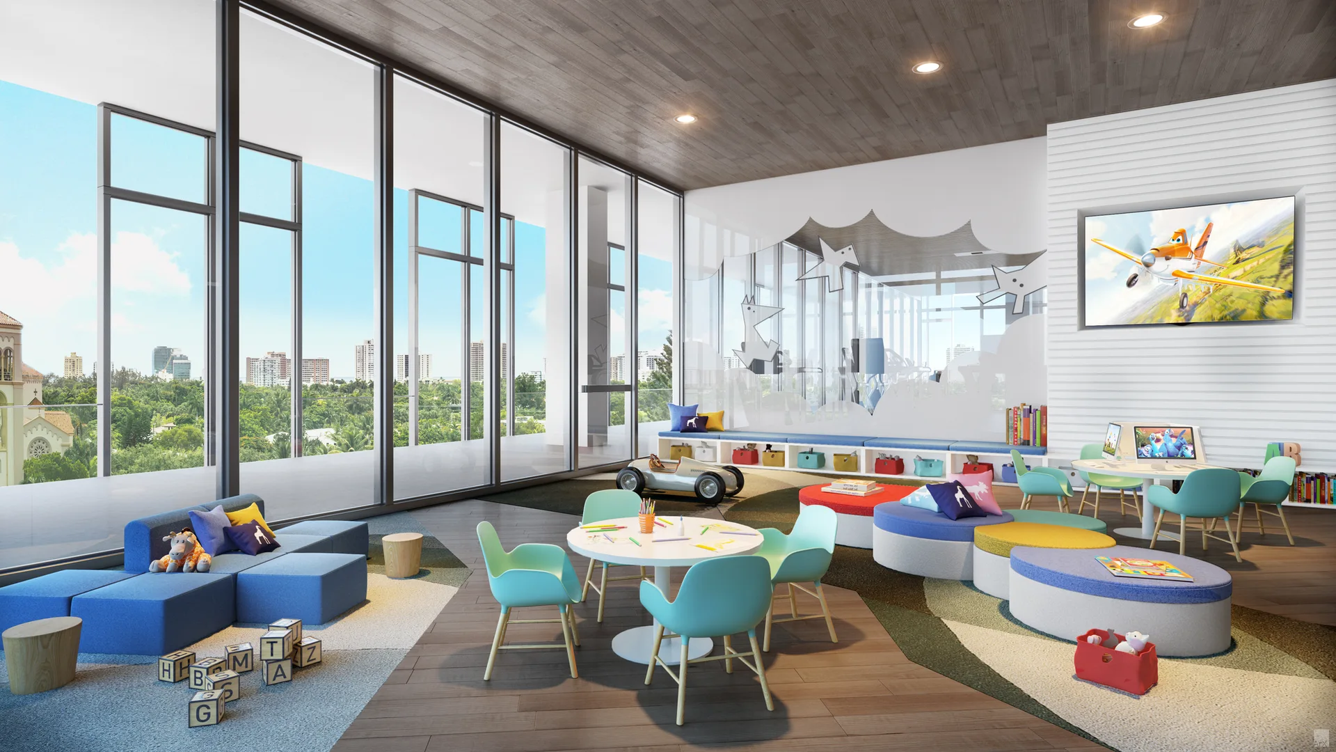 A bright children's playroom features teal chairs, modular blue cushions, a low storage bench, and expansive floor-to-ceiling windows.