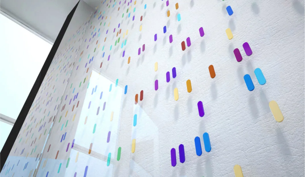A white textured accent wall features small, colorful pill-shaped plastic pieces arranged in vertical lines next to a window.