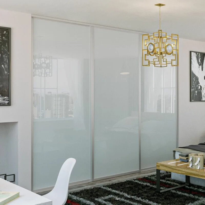 Three large frosted glass sliding closet doors dominate a bedroom wall next to a gold geometric pendant light and a dark textured rug.