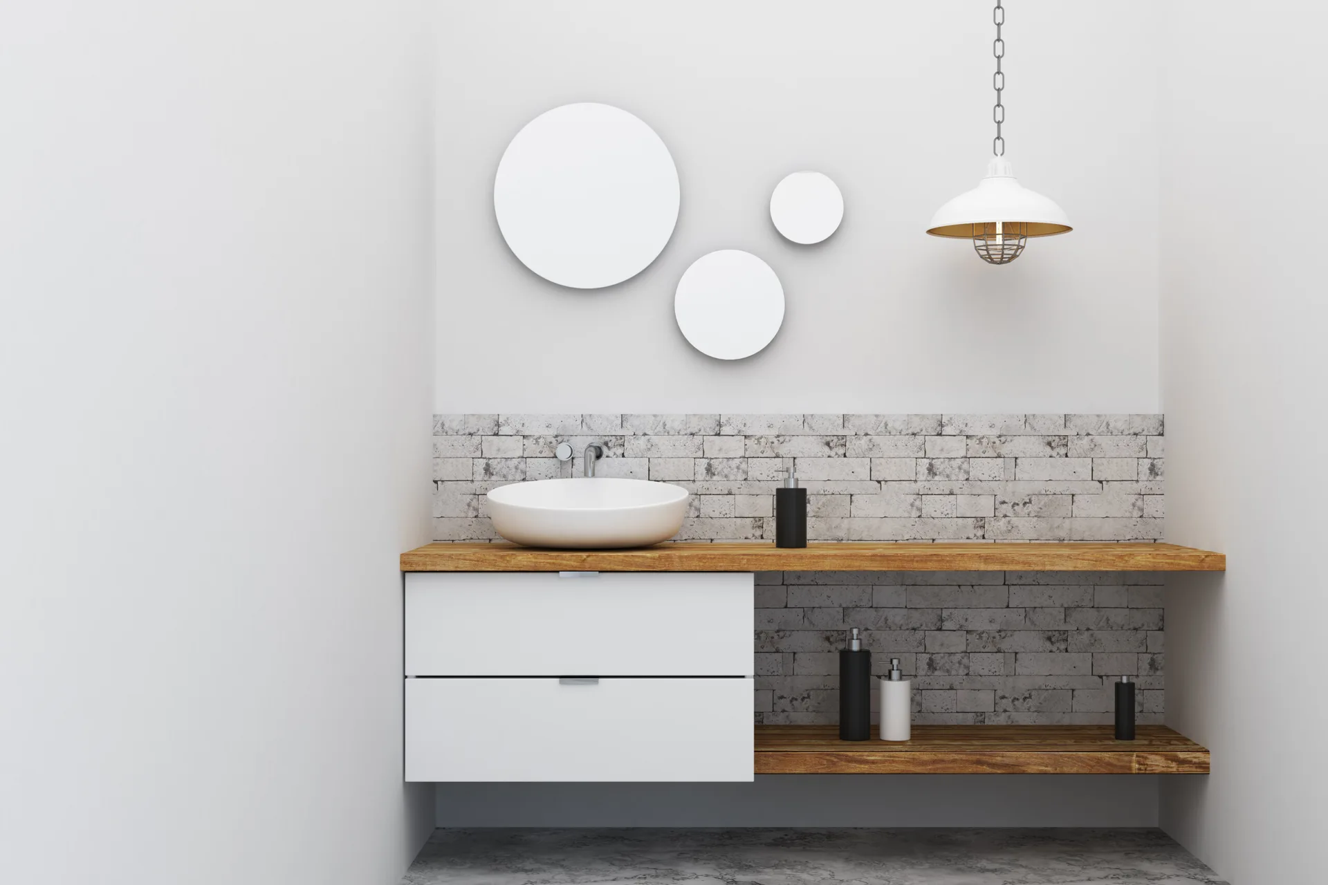 A minimalist wall-mounted wooden bathroom vanity with a white vessel sink, a grey brick backsplash, and three circular wall decorations.