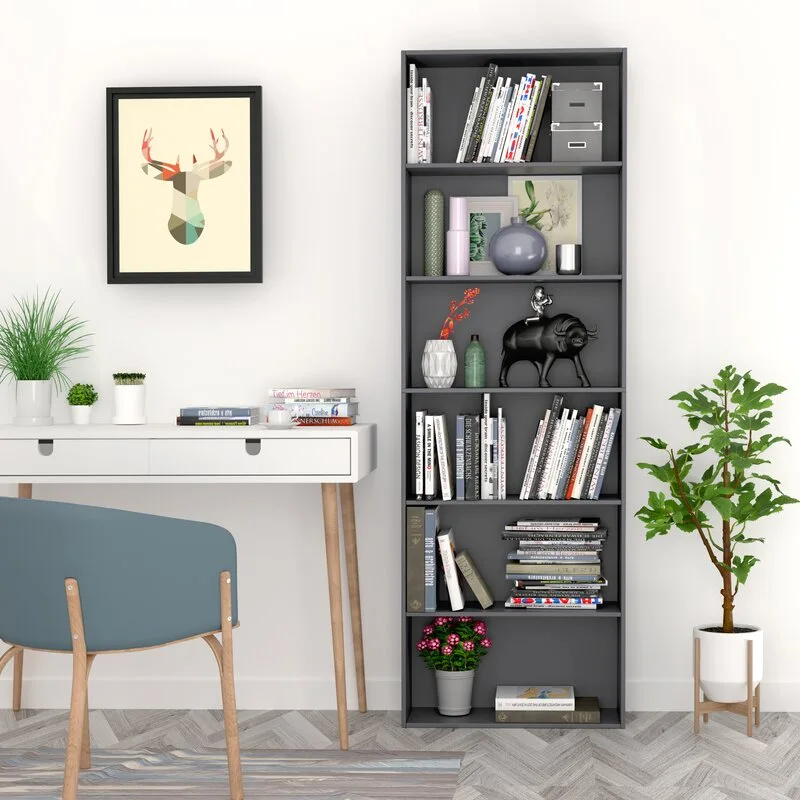 A modern home office workspace features a white writing desk, a blue upholstered chair, a tall charcoal grey bookshelf, and light herringbone floors.