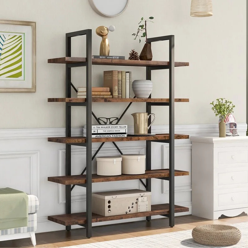 A five-tier wood and black metal open bookshelf displays books and decorative items against an off-white wainscoted wall next to a white chest of drawers.