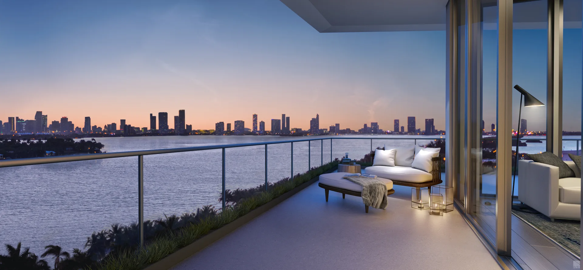 A modern high-rise balcony at dusk features a white outdoor sofa, matching ottoman, glass railing, and floor lanterns overlooking a city skyline.