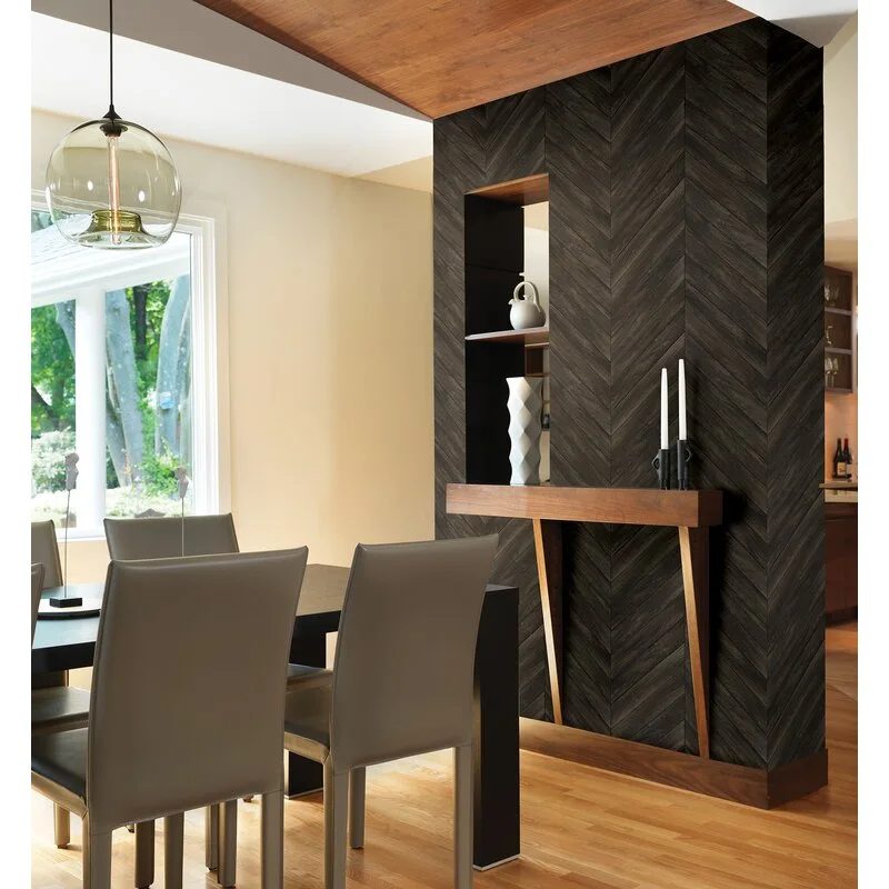 A dining room features a dark wood herringbone accent wall with a built-in niche, grey dining chairs, and a glass globe pendant light.