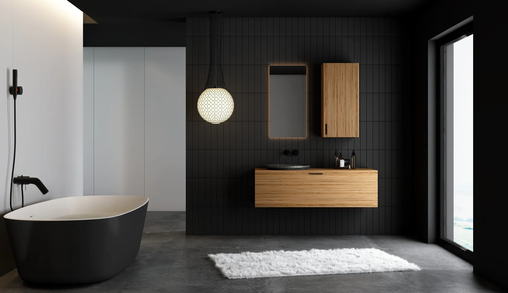 A minimalist bathroom features black vertical wall tiles, a black freestanding bathtub, a floating oak wood vanity, and a glowing globe pendant.